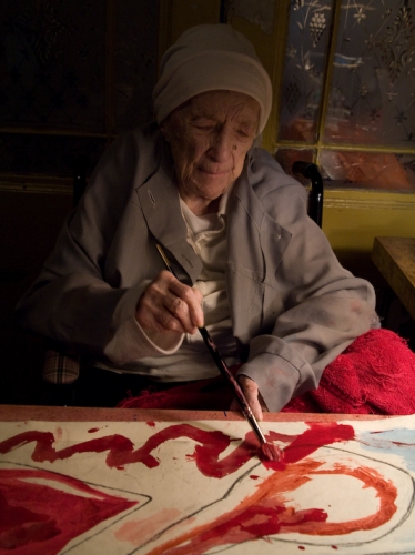 Louise Bourgeois with her hand colored print, LA FAMILLE, in progress in 2009.
Photo: Alex Van Gelder / Art: &copy; The Easton Foundation